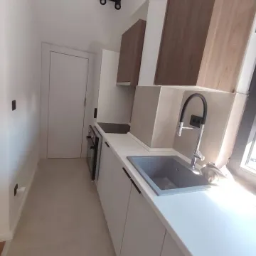 Compact kitchen with a sink, built-in cabinetry, and white countertops. - image 6