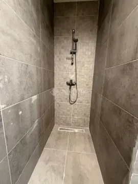 Modern walk-in shower with grey tiles. - image 11
