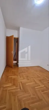Prazna soba sa parketom i otvorenim drvenim vratima. - image 6