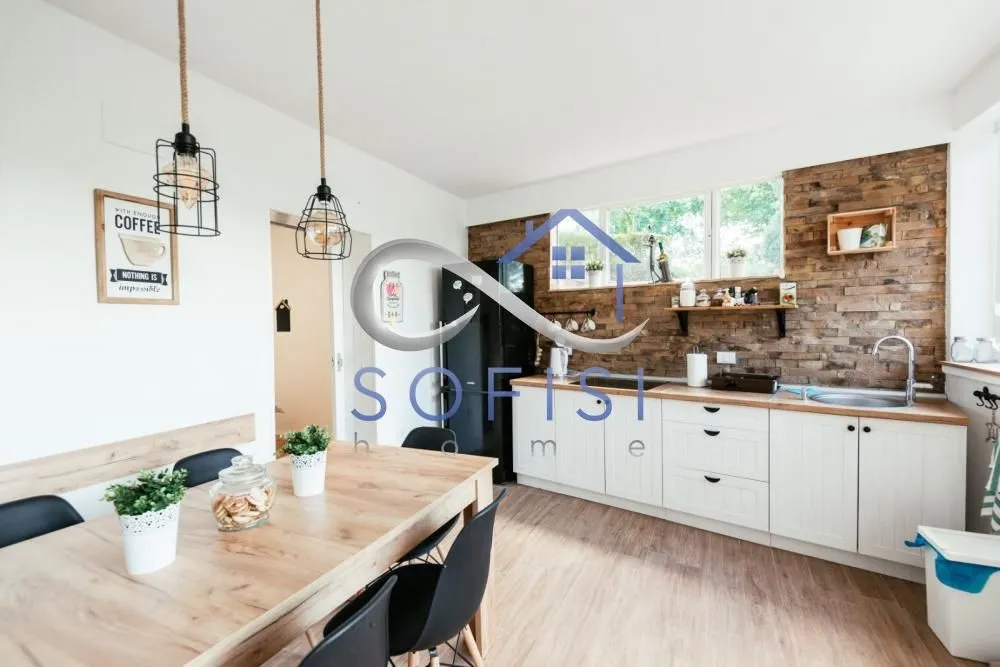 Kitchen with dining area equipped with wooden elements and a dining table.