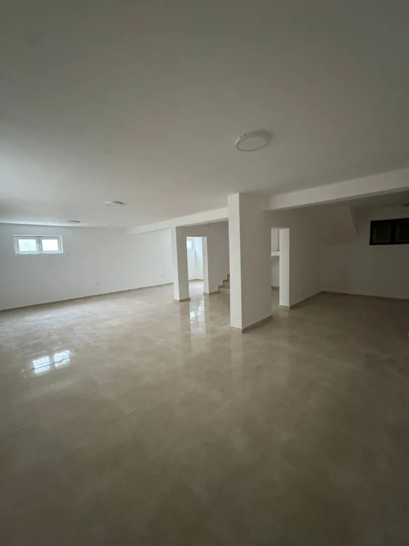 A spacious and bright empty room with light tiled flooring.