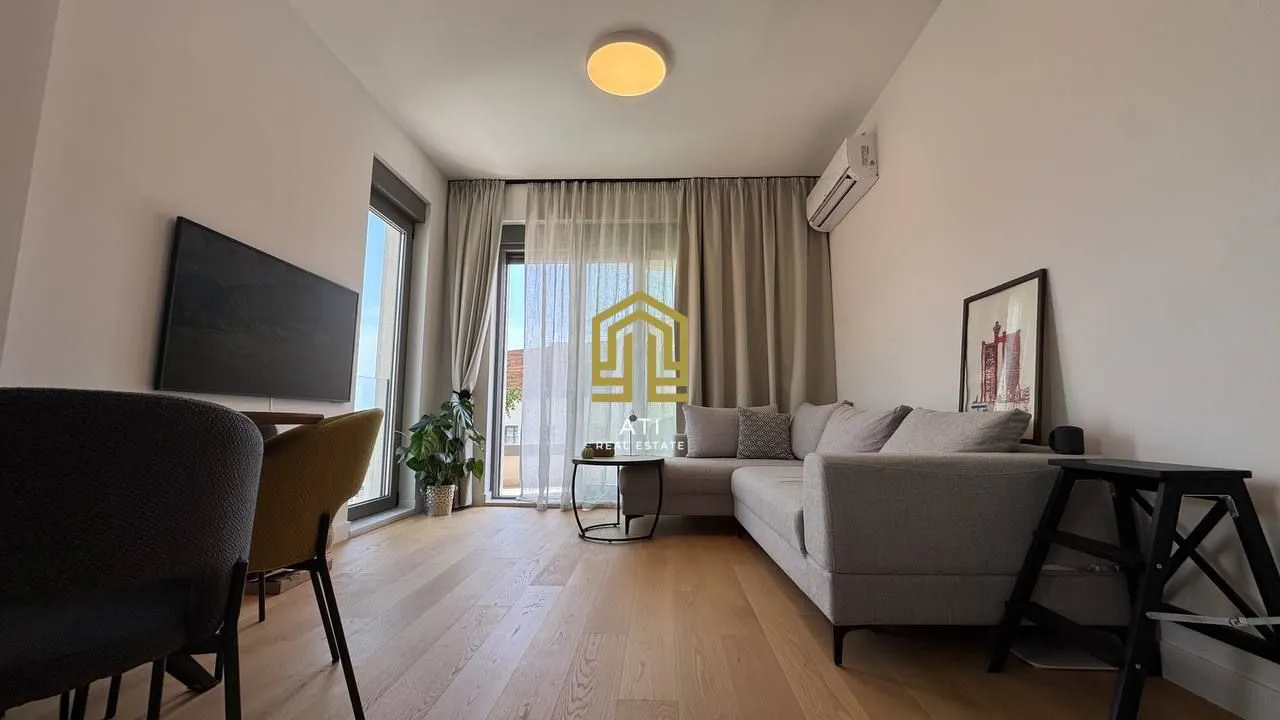 Moderan i svetao dnevni boravak sa ugaonom garniturom i izlazom na terasu.