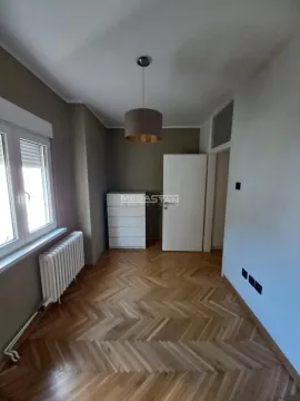 Prazna prostorija sa parketom i belim vratima. - image 10