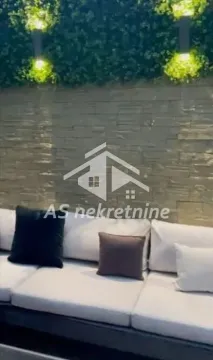 Uređena terasa sa garniturom za sedenje i dekorativnim osvetljenjem na zidu. - image 6