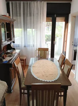 Dining room with a wooden table, chairs, and a cabinet. - image 4