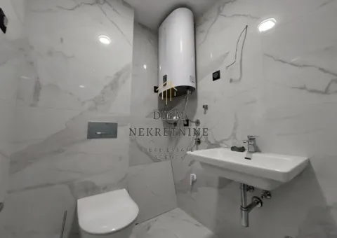 Moderne kupatilo sa bijelim mermernim pločicama, umivaonikom, WC šoljom i bojlerom. - image 8