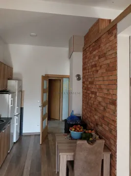 Kuhinja sa trpezarijskim stolom i zidom obloženim ciglom. - image 5
