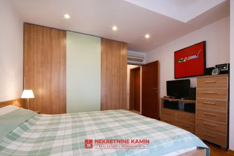 Furnished bedroom with a double bed, wardrobe, and a dresser with a TV. - image 15