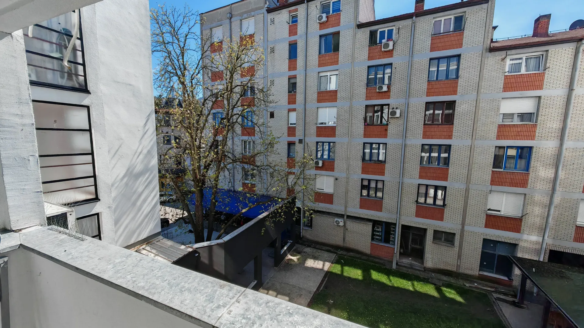 Pogled sa terase na dvorište i okolne zgrade.