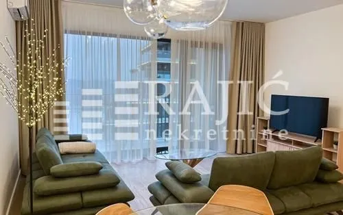 Spacious and bright living room with a sofa and large windows.