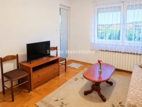 Living room with sofa, television, and wooden furniture. - image 10