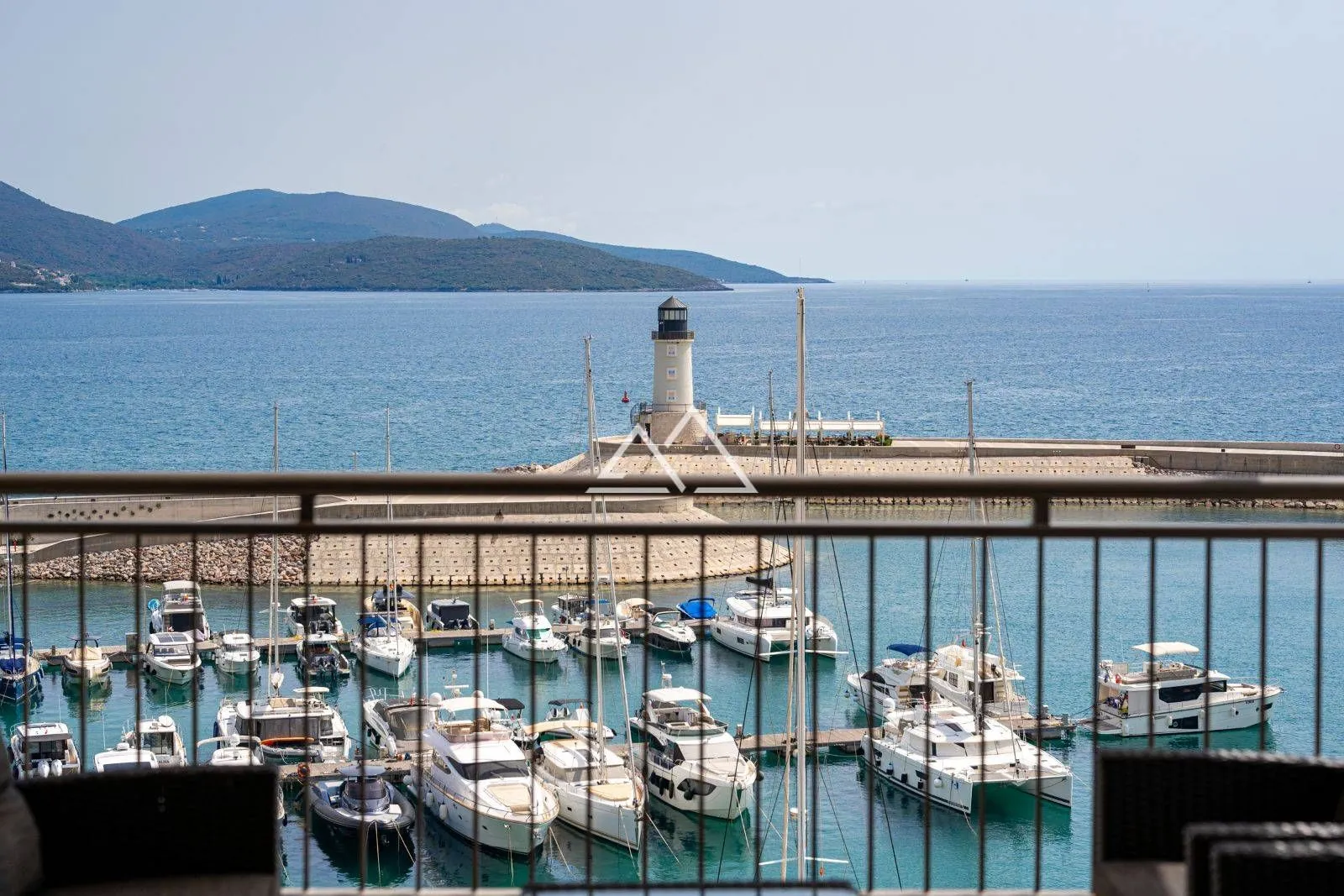Pogled sa terase na marinu sa brodovima i svjetionik.
