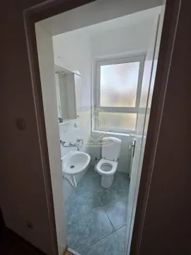 View from the hallway into a small bathroom with a sink and toilet. - image 13