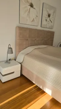A decorated bedroom with a double bed, nightstand, and paintings on the wall. - image 10