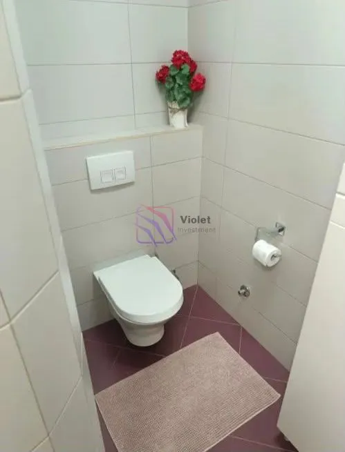 Manje kupatilo sa WC šoljom i keramičkim pločicama.