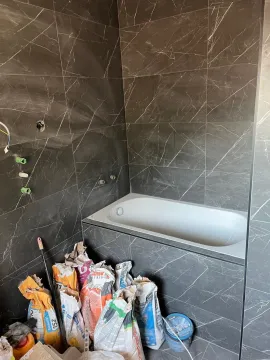 Kupatilo u fazi renoviranja sa ugrađenom kadom i građevinskim materijalom. - image 10