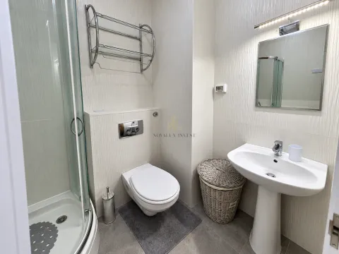 Modern bathroom with a shower cabin, washbasin, and wall-mounted toilet. - image 5