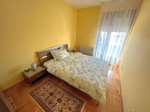 Spavaća soba sa bračnim krevetom, noćnim stočićima i prozorom sa svijetlim zavesama. - image 7