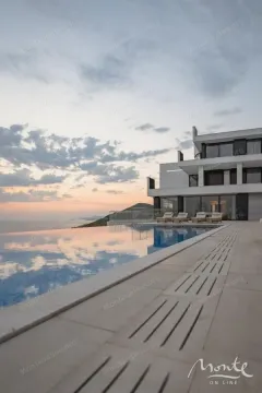 Modern villa with a swimming pool and sea view at dusk. - image 29