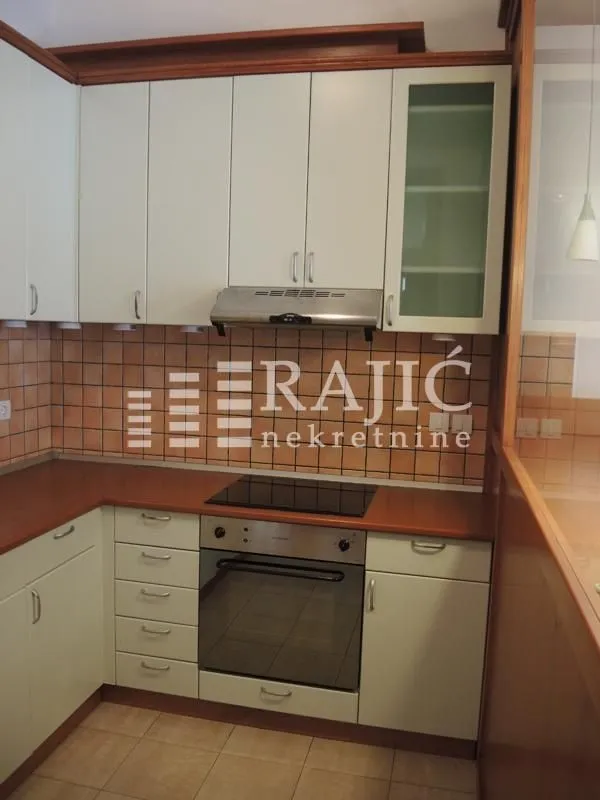 View of the kitchen with wooden elements and built-in appliances.