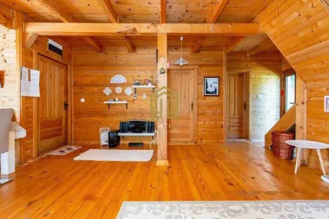 Interior of a living room with wooden wall panels and a staircase. - image 9