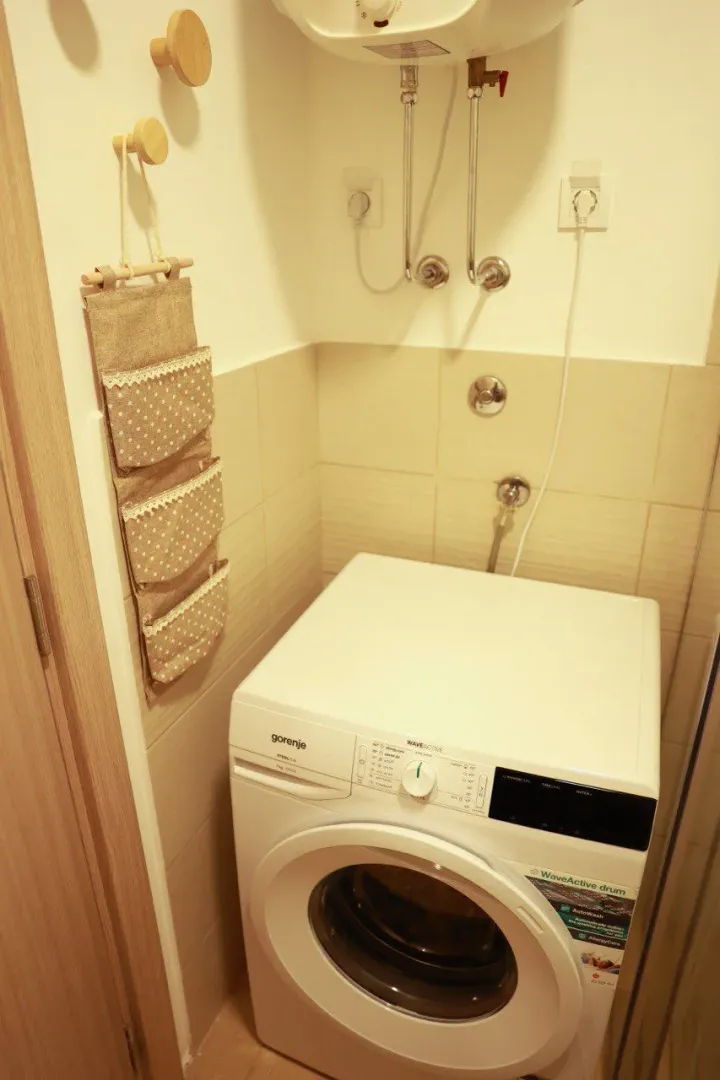 Bathroom with a washing machine and a water heater.