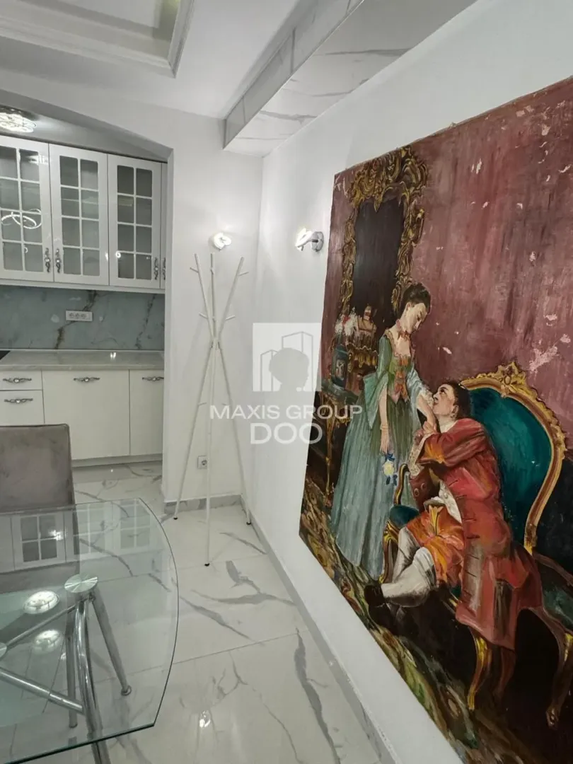 Manja kuhinja sa belim elementima i trpezarijskim stolom u produžetku.