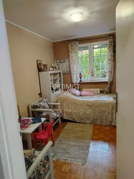 Nameštena spavaća soba sa krevetom, foteljom i prozorom. - image 6