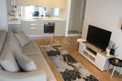 Living room with sofa and TV, connected to the kitchen in an open plan space. - image 6
