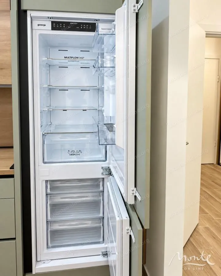 Ugrađeni frižider sa otvorenim vratima u modernoj kuhinji.