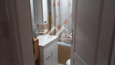 Pogled na kupatilo sa umivaonikom i kadom kroz otvorena vrata. - image 2