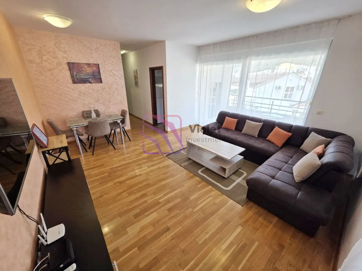 Living room with a sofa, dining area, and access to the balcony.