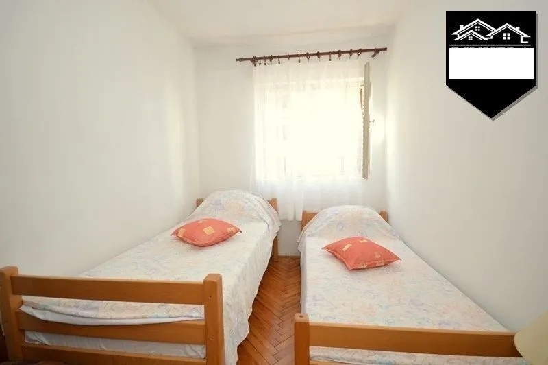 Smaller bedroom with two single beds and a window.