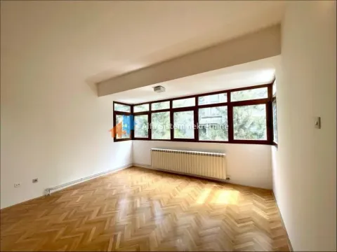 Empty room with hardwood flooring and large windows. - image 10