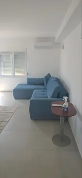 Dnevna soba sa plavom ugaonom garniturom i malim stočićem. - image 2