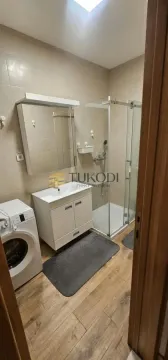 Kupatilo opremljeno umivaonikom, tuš kabinom i mašinom za pranje veša. - image 3