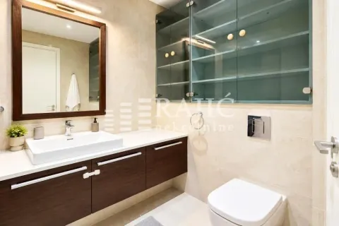 Modernly equipped bathroom with a washbasin, mirror, and toilet. - image 7