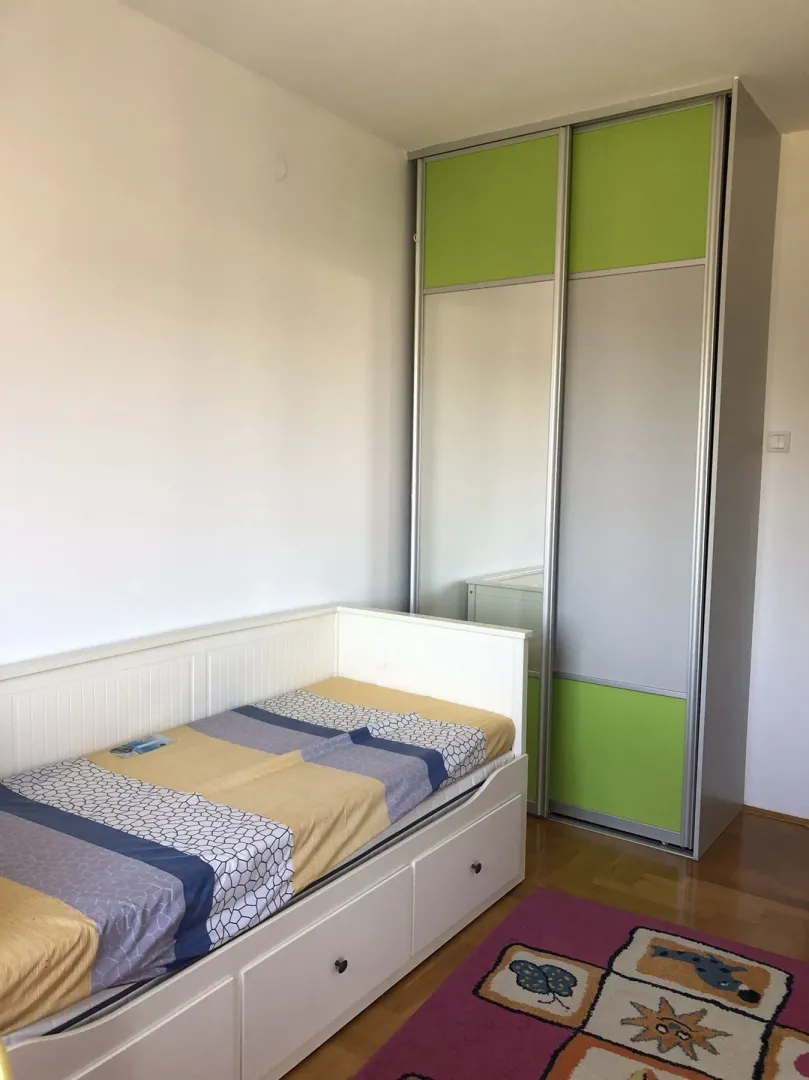 Kids' bedroom with a bed and a wardrobe.