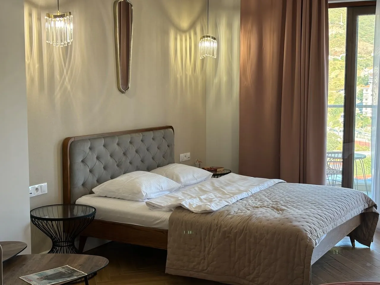 Moderna spavaća soba sa bračnim krevetom, elegantnom rasvjetom i izlazom na terasu.