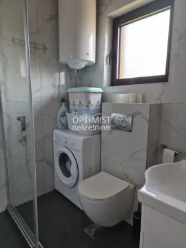 Kupatilo opremljeno tuš kabinom, wc šoljom, umivaonikom i veš mašinom. - image 7