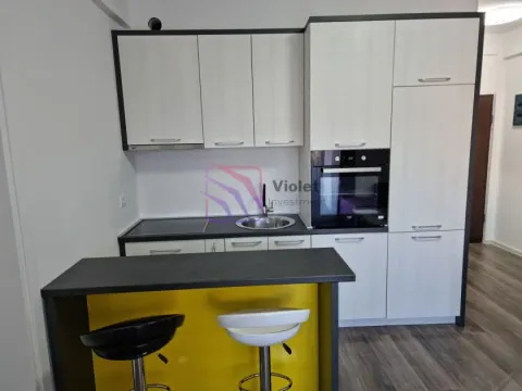 Kuhinja sa bijelim elementima, ugradnom rernom i šankom sa barskim stolicama. - image 3