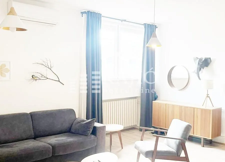 Bright living room with a sofa set and a wooden dresser.