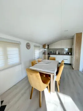 Dining area with a table and chairs and a view of the kitchen in the background. - image 12