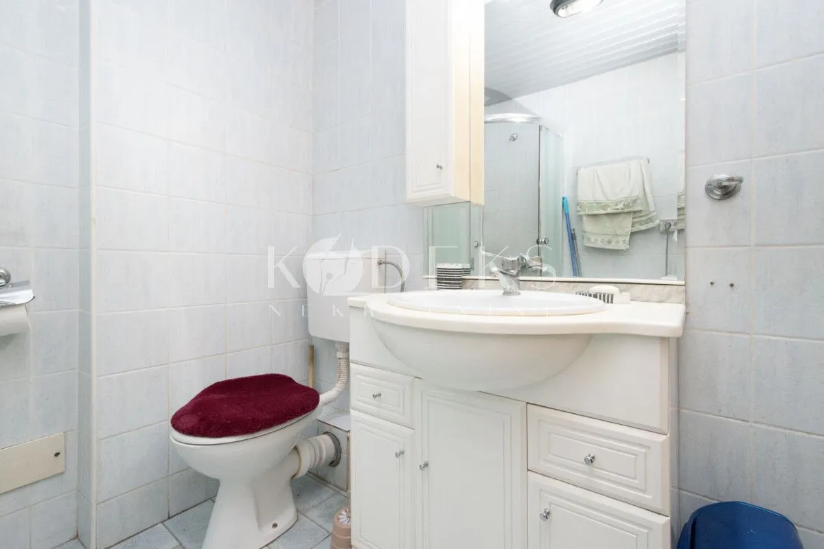 Kupatilo sa umivaonikom, ormarićem, ogledalom i wc šoljom.