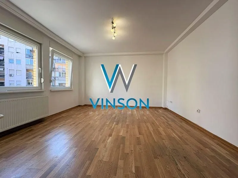 Empty room with parquet flooring and white walls.
