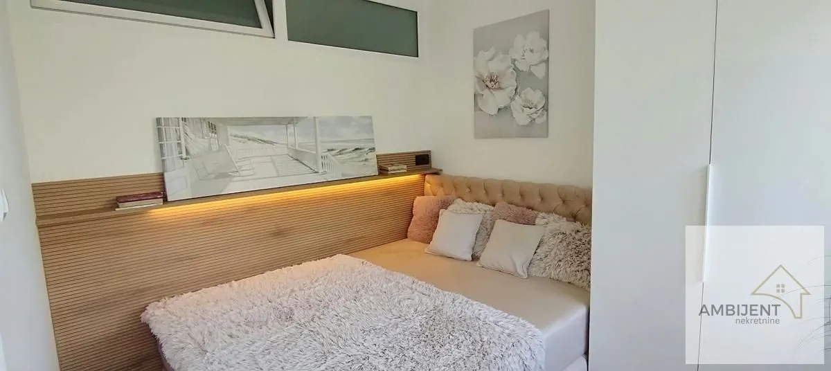 Small bedroom with a double bed and decorative wall panels.