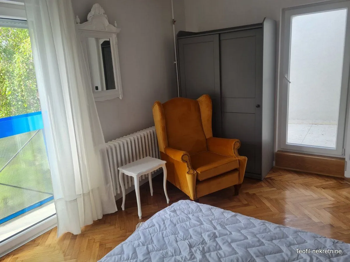 Bedroom with a yellow armchair, wardrobe, and bed.