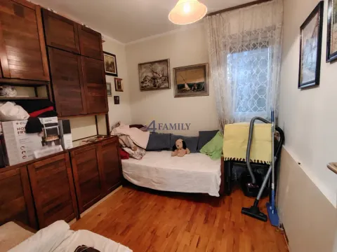Manja dnevna soba sa krevetom i drvenim ormarima. - image 6
