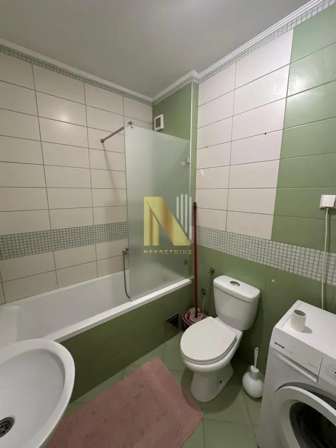 Kupatilo opremljeno kadom, umivaonikom, WC šoljom i veš mašinom.