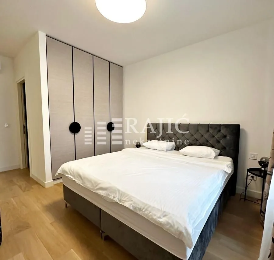 Furnished bedroom with a double bed and built-in wardrobe.
